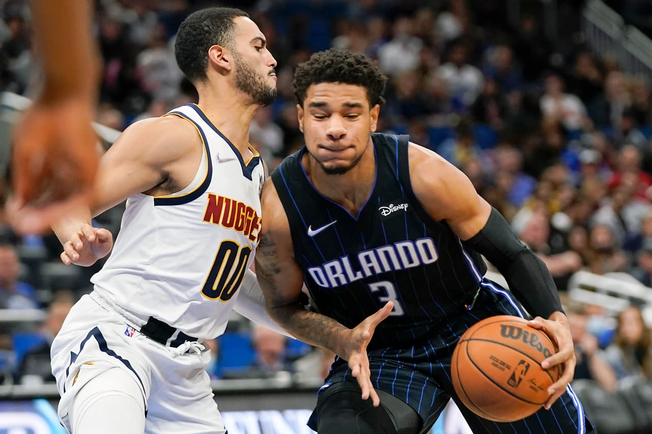Chuma Okeke de los Orlando Magic con el balón en la mano marcado por Markus Howard (00) de los Nuggets de Denver.