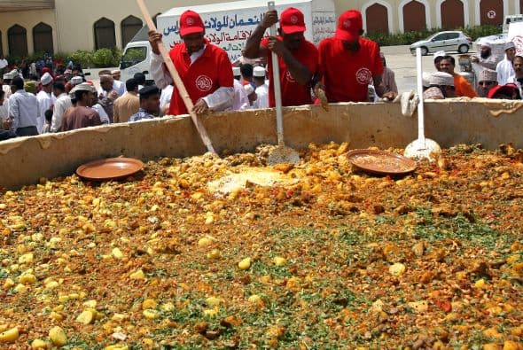 Hombres de Omán revuelven los ingredientes para preparar uno de su platillos típicos, el 'Kabsa', en un inmenso contenedor para romper el Récord Guinness en julio del 2010.