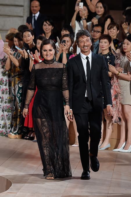 Valentino. Maria Grazia Chiuri y Pierpaolo Piccioli estudiaron en el Instituto Europeo de Diseño de Roma y sus caminos se encontraron en el estudio de diseño de Fendi. Actualmente son los directores creativos de Valentino. Su acercamiento estético combina diversos estilos y métodos que conservan la esencia de la casa, fundada por Valentino Garavani.