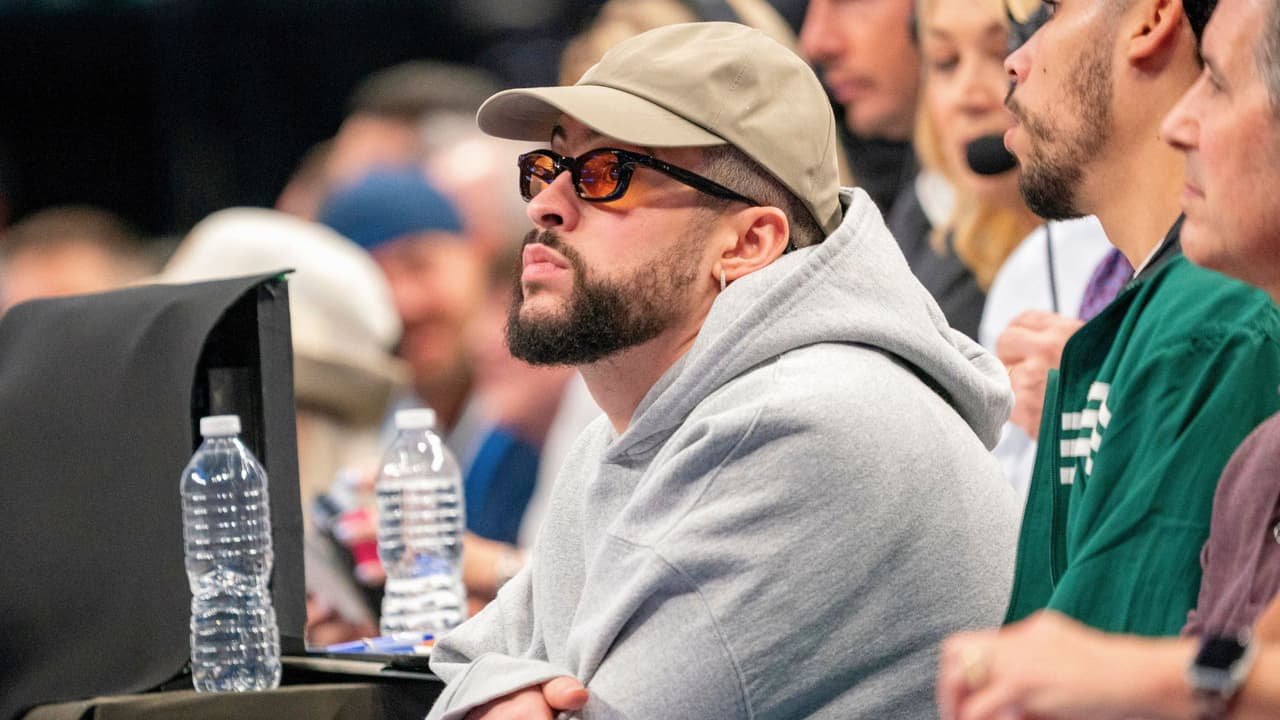 Bad Bunny se sienta en la cancha durante la primera mitad del cuarto partido de la primera ronda de los playoffs de baloncesto de la NBA entre los Dallas Mavericks y Los Angeles Clippers, el domingo 28 de abril de 2024, en Dallas.