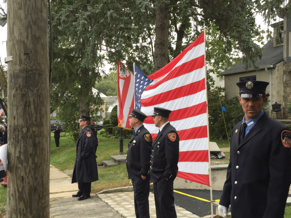 Mucho antes de las 12:00 del mediodía, los bomberos comenzaron a desplegar banderas en la ruta hacia a la iglesia del féretro del capitán Fahy.