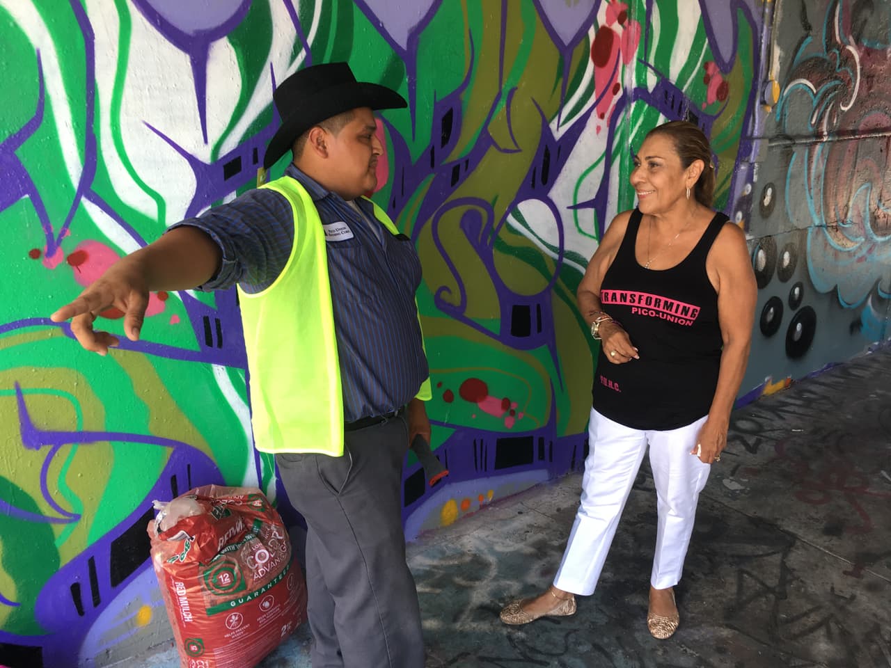 Gloria Farías conversa con un asistente de la organización Pico Union Housing Corp.