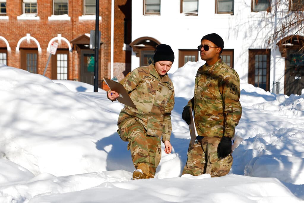 Miembros de la Guardia Nacional revisan casa por casa en busca de sobrevivientes de la tormenta invernal en el estado de Nueva York.