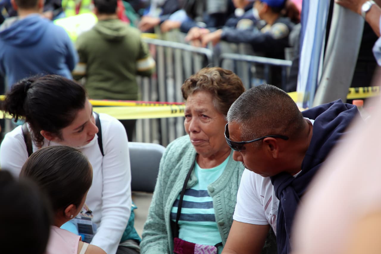 Los familiares de los desaparecidos en Álvaro Obregón esperan informes sobre las labores de rescate bajo una carpa habilitada cerca de las ruinas.