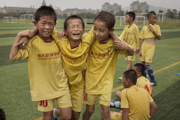 Estos niños ayudan a su compañerito lastimado a salir del campo.