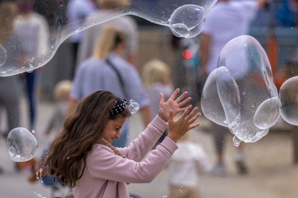 Una niña 
<b>juega con burbujas cerca del muelle de Santa Mónica</b> mientras las multitudes se reúnen en el Día de los Caídos mientras los cierres se relajan más de un año después de que comenzaran los cierres por el covid-19, en Santa Mónica, California.