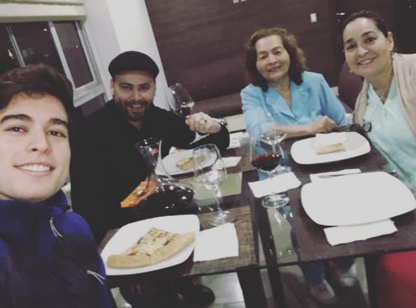 Cenando en familia una deliciosa pizza y vino tinto.