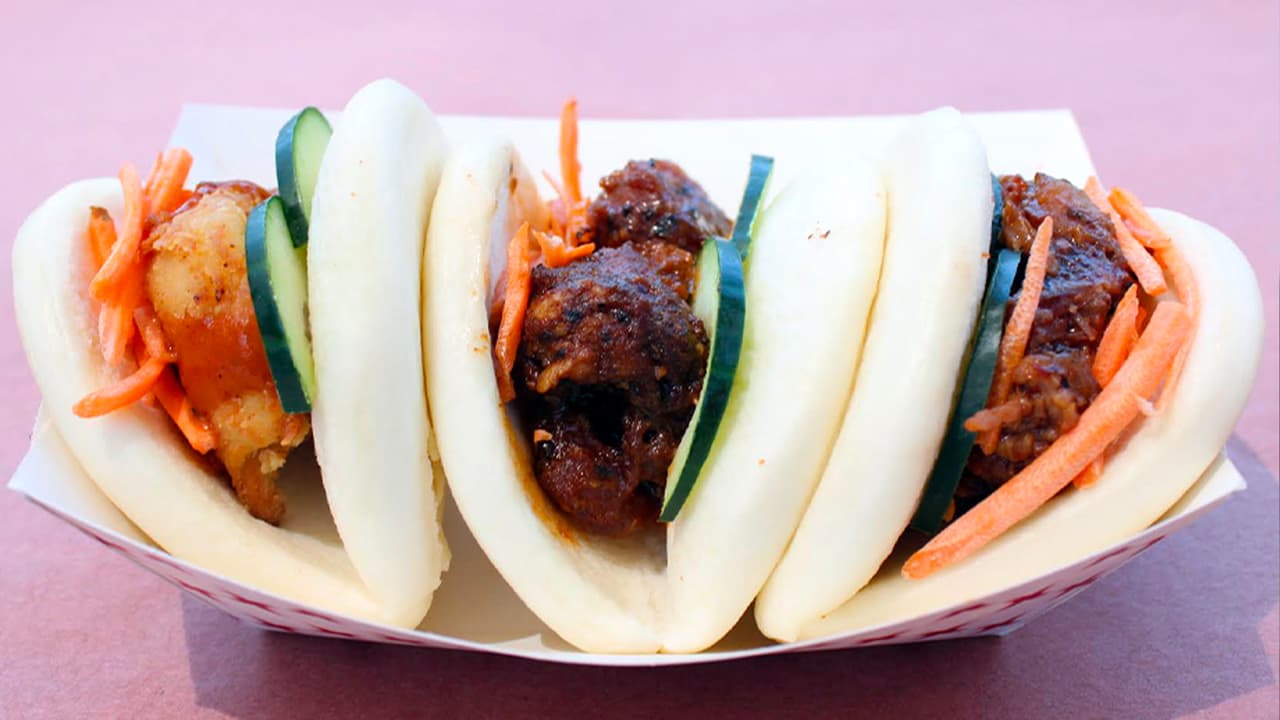 <b>BAO BUN TACO TRIO</b> de East Meets West BBQ Fusion
<br>Lo describen como todo un
<i>“paraíso para los amantes de la carne”</i>. Uno viene relleno de pollo frito, otro de cerdo y el tercero de panza.
<b>Puedes probar uno o ¡el trío completo!</b>