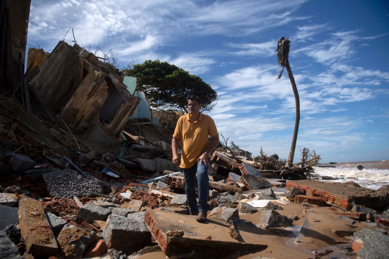 Una de las próximas casas que será comida por el mar es la del empresario Joao Waked Peixoto, de 49 años, (en la foto). El hombre camina frente a una casa que se derrumbó justo al lado de la suya, en la playa de Atafona.
<br>
