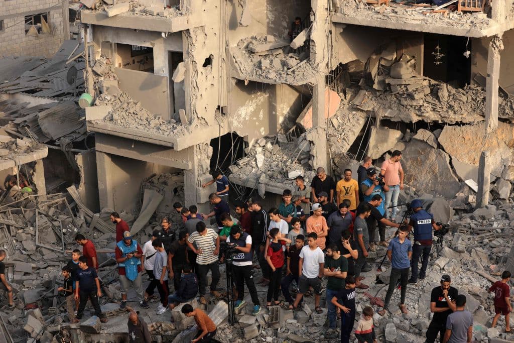 Personas observan el daño y la destrucción causa pro un ataque israelí en el campo de refugiados de Al-Maghazi, en la parte central de la Franja, en donde muchos palestinos del norte han buscado refugio, advertidos por Israel.