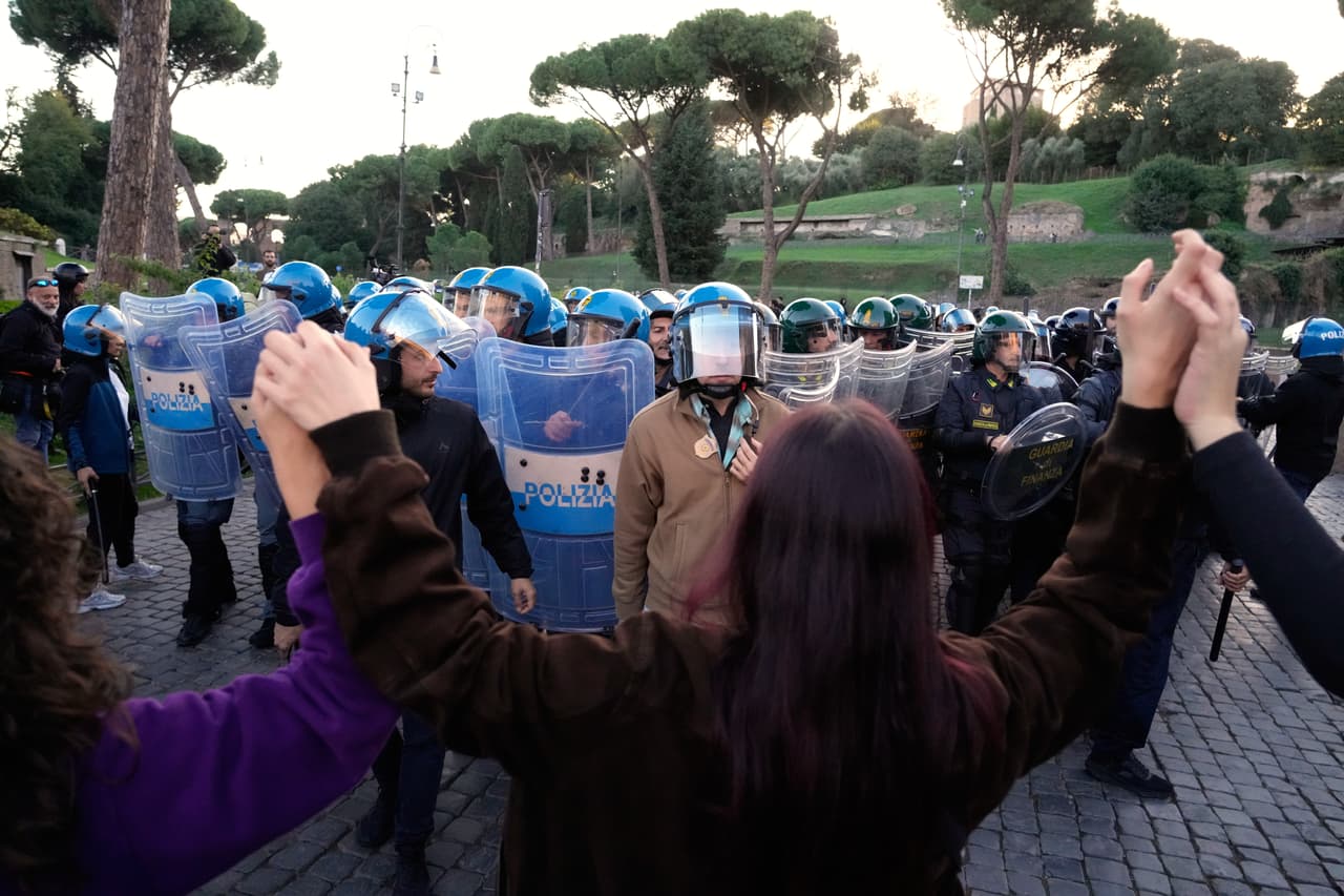 Policías antidisturbios italianos observan a activistas pacifistas que se manifiestan contra el rearme y la participación de Italia en guerras en Roma, el sábado 24 de octubre de 2026.