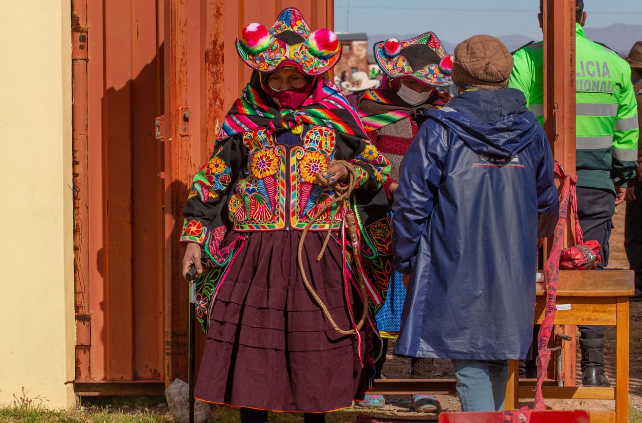 Personas vistiendo la típica ropa quechua al entrar a una centro de votación en la localidad andina Capachica, cerca de la frontera con Bolivia. El candidato izquierdista Pedro Castillo es fuerte en las zoas rurales del Perú.