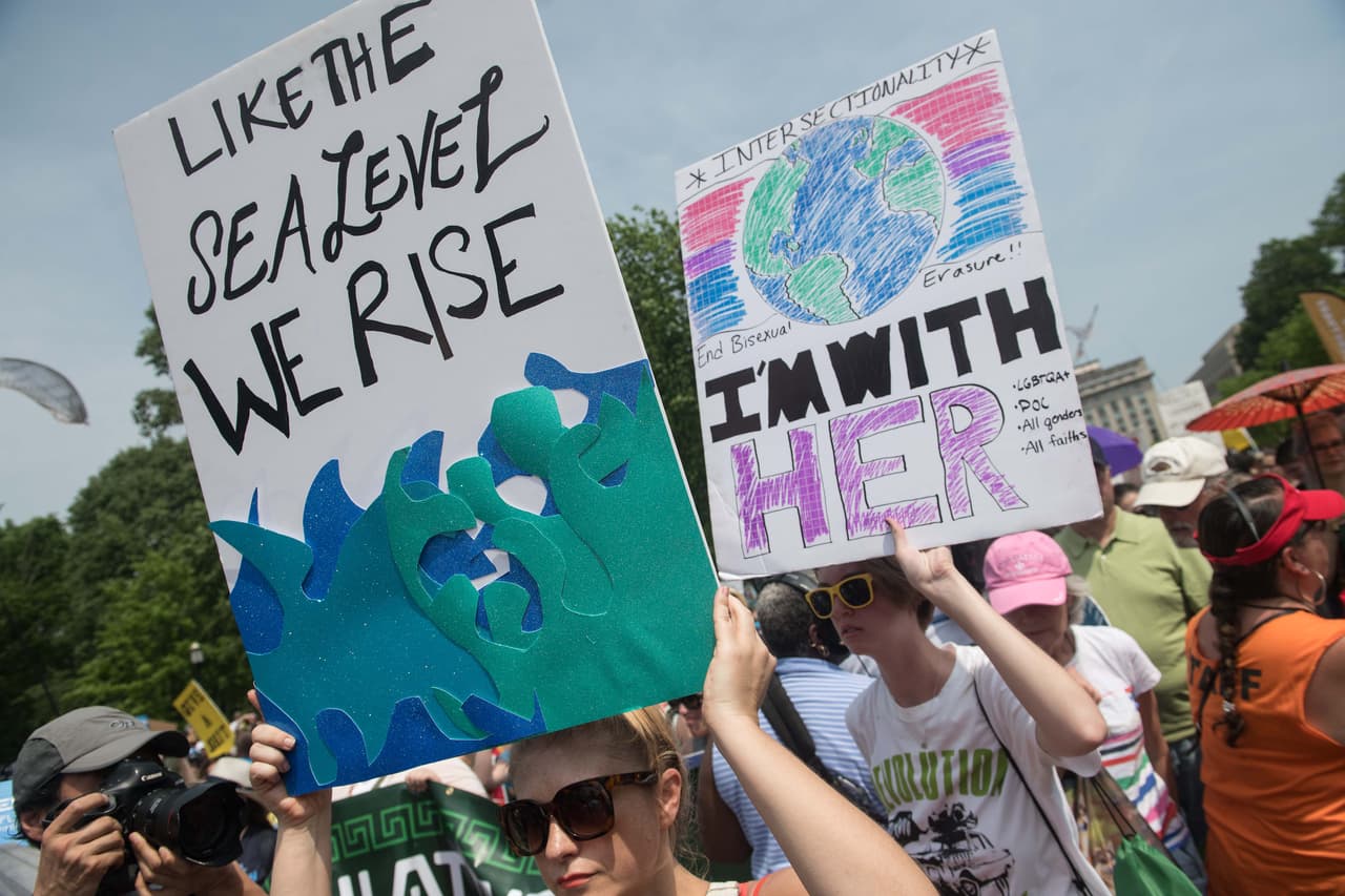 "Como el nivel del mar, nos alzamos" y "Y estoy con ella" junto a una ilustración de nuestra Tierra son algunos de los treros creativos que se pbservan en la parcha por el clima de este sábado.
