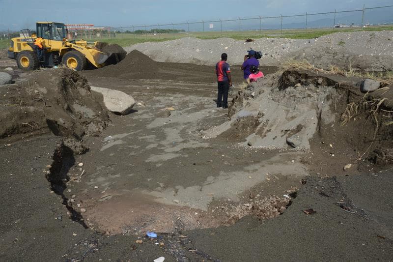 Una excavadora trabaja en Kingston, Jamaica, en retirar arena removida por las lluvias que ha comenzado a llevar Matthew.