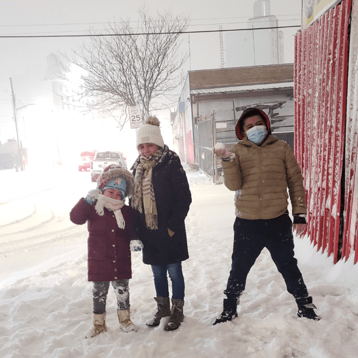 Tres niños posan disfrutando de la nieve durante la primera fuerte tormenta invernal de la temporada.