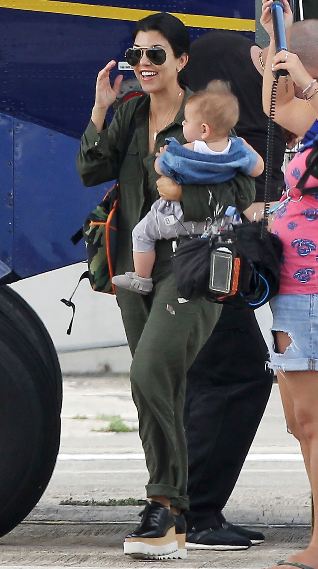 Kourtney viajó muy cómoda con un jumpsuit verde.