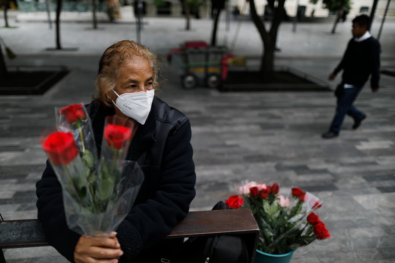 Con una máscara para frenar la propagación del coronavirus, Martha González Reyes, de 76 años, vende rosas en las afueras de Metro Hidalgo en el centro de la Ciudad de México.