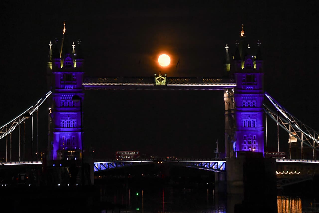 La Superluna se eleva detrás del Tower Bridge de Londres, el jueves 7 de mayo de 2020. La agencia espacial
<a href="https://solarsystem.nasa.gov/news/1220/the-next-full-moon-is-a-supermoon-flower-moon/" target="_blank">NASA</a> señala además que la Luna llena de mayo se le llama también de leche y de maíz, dependiendo de las diferentes tradiciones.
<br>