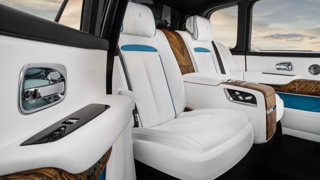 La experiencia de lujo comienza con solo destrabar el cerrojo, lo que hace que la Rolls-Royce Cullinan
<b> descienda 40 milímetros de altura </b>para facilitar el acceso la lujosa cabina del vehículo. Una vez que se enciende su motor la Cullinan recupera la altura para alistarse para el recorrido. La fila de asientos trasera en la configuración para 4 pasajeros es un lugar verdaderamente lujoso, al cual se accede a través de puertas con bisagras en la parte trasera estilo suicida. La consola central es una verdadera caja de sorpresas. La misma alberga todo tipo de controles, incluyendo para los asientos que por cierto son totalmente configurables, espacios para almacenamiento, porta vasos,
<b>refrigerador</b>,
<b>flautas para champagne</b>,
<b>vasos para whisky</b> y hasta un
<b>decantador</b>. Su precio inicial es de
<b>325,000 dólares</b>. De allí en adelante, el cielo es el límite.