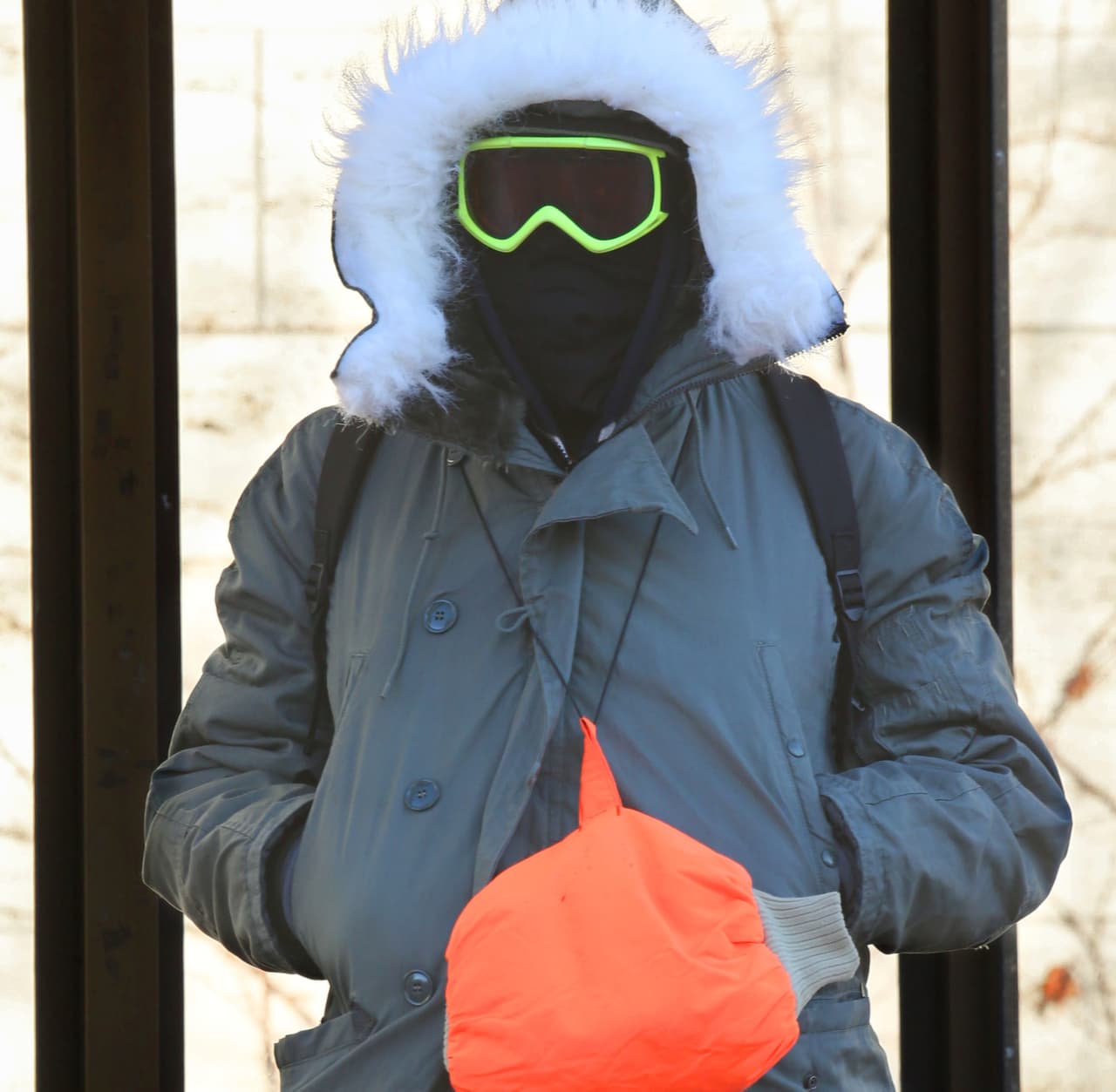 Austin espera el autobus a lo largo de Shorewood, Wisconsin.
