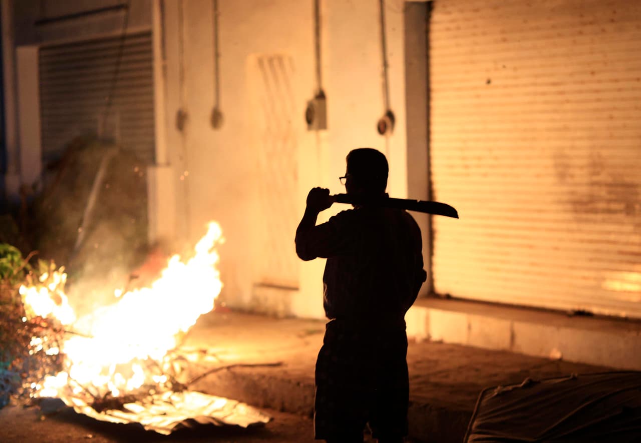 Un hombre permanece de guardia afuera de su casa el 29 de octubre de 2023, en una zona afectada por el paso del huracán Otis, en el balneario de Acapulco, en el estado de Guerrero, México.