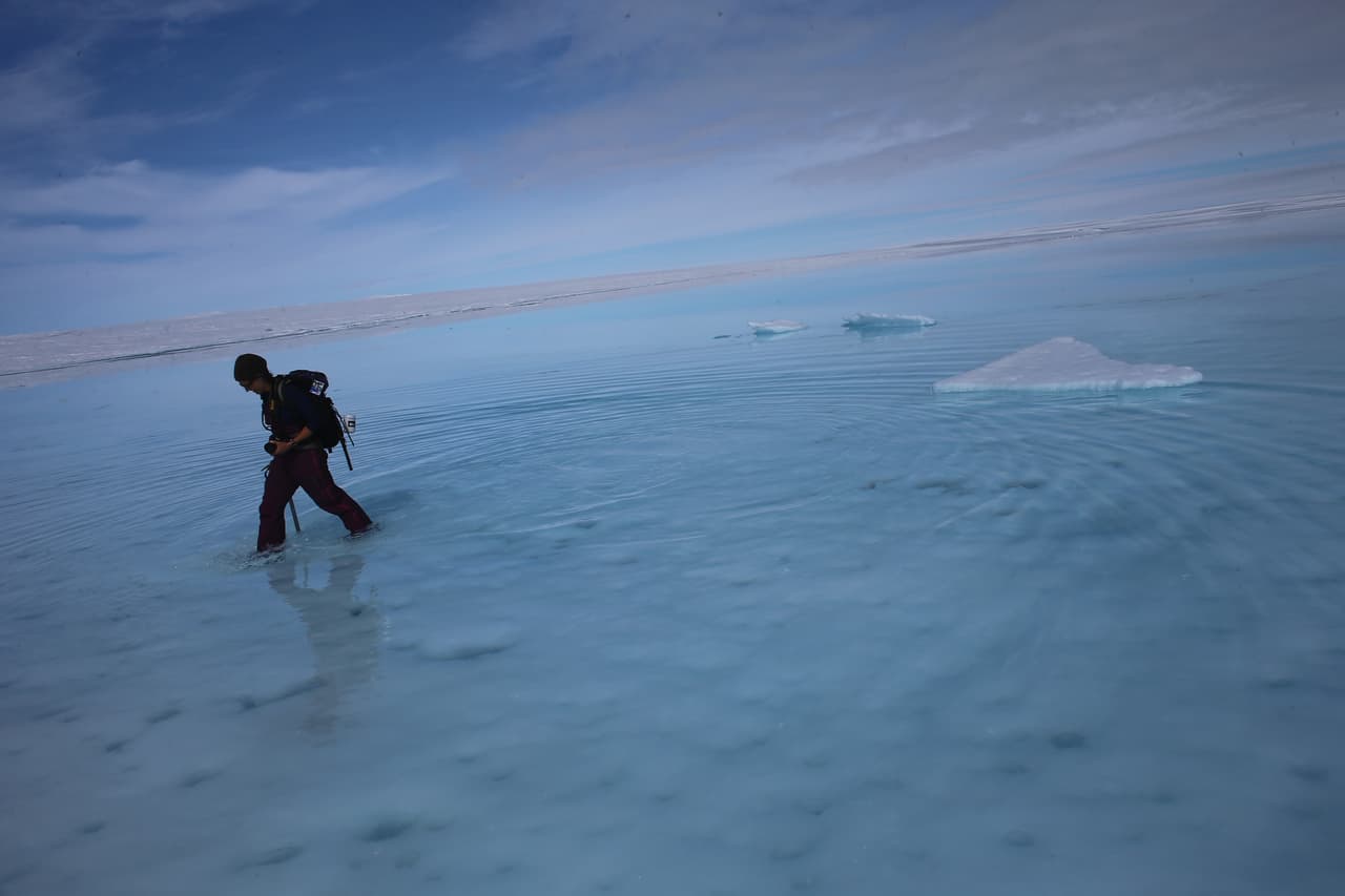 GLACIAL ICE SHEET, GREENLAND - JULY 16: Sarah Das from the Woods Hole Oceanographic Institution walks though a surface meltwater lake on July 16, 2013 on the Glacial Ice Sheet, Greenland. She is part of a team of scientists that is using Global Positioning System sensors to closely monitor the evolution of the surface lakes and the motion of the surrounding ice sheet. As the sea levels around the globe rise, researchers affilitated with the National Science Foundation and other organizations are studying the phenomena of the melting glaciers and its long-term ramifications. The warmer temperatures that have had an effect on the glaciers in Greenland also have altered the ways in which the local populace farm, fish, hunt and even travel across land. In recent years, sea level rise in places such as Miami Beach has led to increased street flooding and prompted leaders such as New York City Mayor Michael Bloomberg to propose a $19.5 billion plan to boost the citys capacity to withstand future extreme weather events by, among other things, devising mechanisms to withstand flooding. (Photo by Joe Raedle/Getty Images)