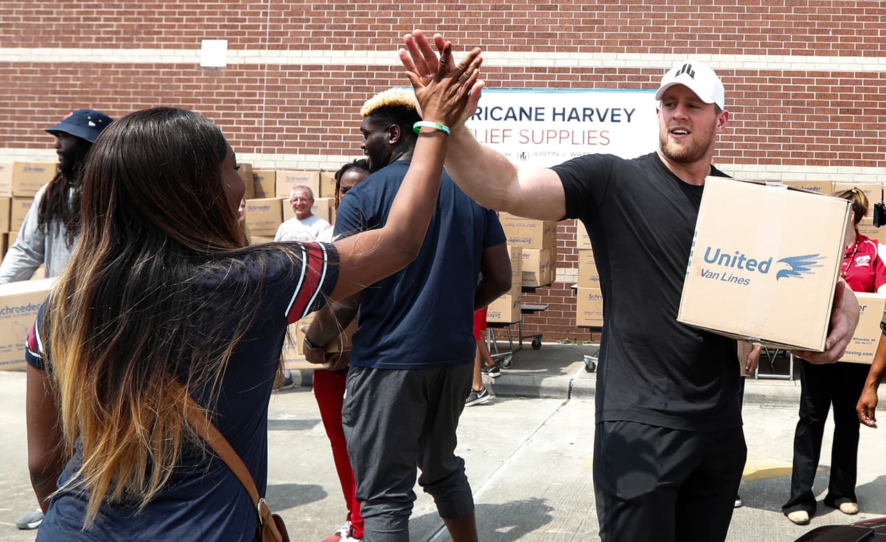 Anna Ucheomumu, left, high fives Houston Texans defensive end J.J. Watt after loading a car with relief supplies to people impacted by Hurricane Harvey on Sunday, Sept. 3, 2017, in Houston. Watt's Hurricane Harvey Relief Fund has raised millions of dollars to help those affected by the storm. (Brett Coomer/Houston Chronicle via AP, Pool)