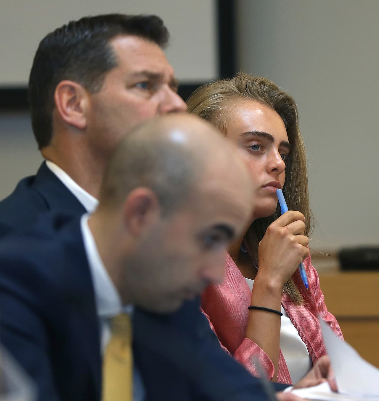 Michelle Carter escucha un testimonio durante su juicio, acompañada por sus dos abogados: Cory Madera en primer plano, seguido de Joe Cataldo.