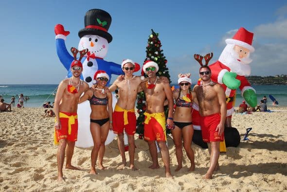Salvavidas posan frente a sus decoraciones de Navidad en Bondi Beach, en Sidney, Australia.