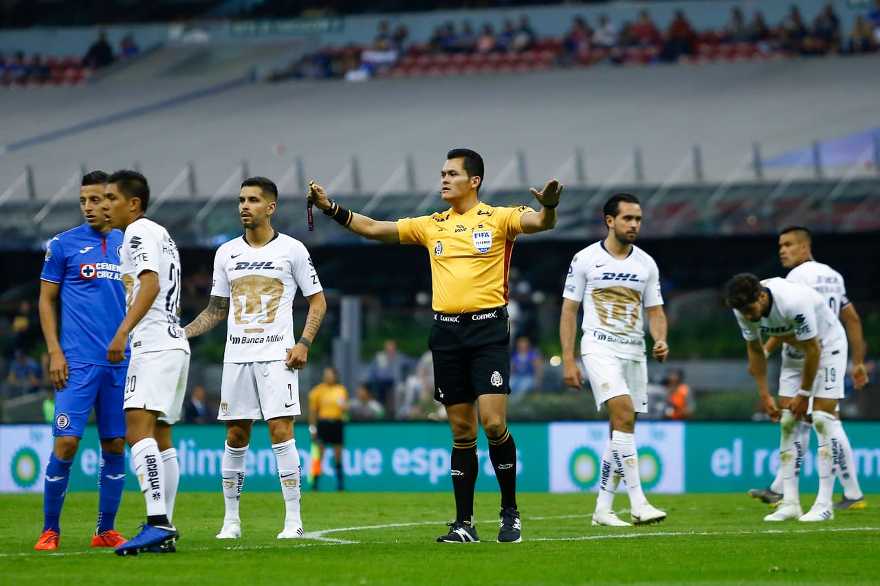 Alan Mozo había anotado el gol del empate 2-2 para Pumas al minuto 75', pero el árbitro Jorge Antonio Pérez (centro) invalidó la acción tras revisar en el VAR.