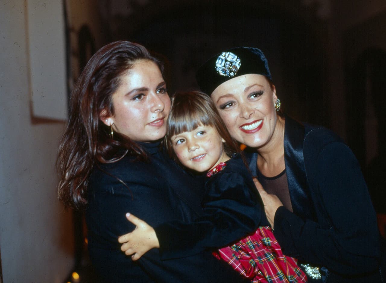 La niña creció sin la figura de su padre y rodeada por las mujeres del clan Pinal. En la foto aparece de niña junto con 
<b><a href="https://www.univision.com/famosos/sylvia-pasquel-se-deprimio-porque-la-familia-pinal-se-convirtio-en-un-burdel-tras-los-ataques-de-frida-sofia-fotos" target="_blank">su abuela Sylvia Pasquel</a></b> (derecha). Mientras tanto, ante la opinión pública prevalecía el mito de que era la hija del famoso cantante. 
<br>