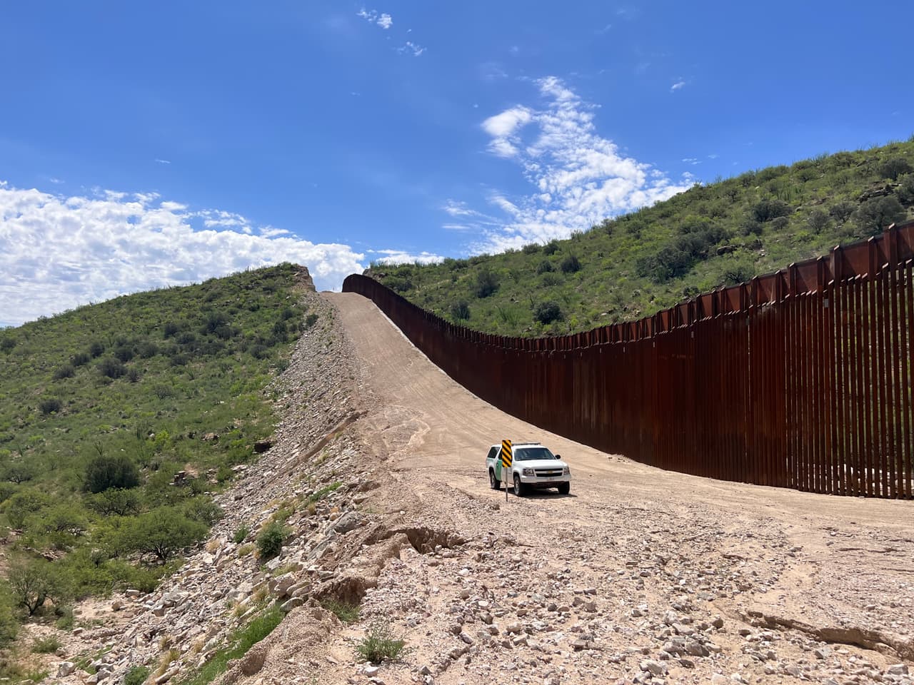 Los migrantes cruzan por el espacio del muro, algunos se entregan a las autoridade migratorias, otros deciden continúar su camino en medio de piedras y arbustos