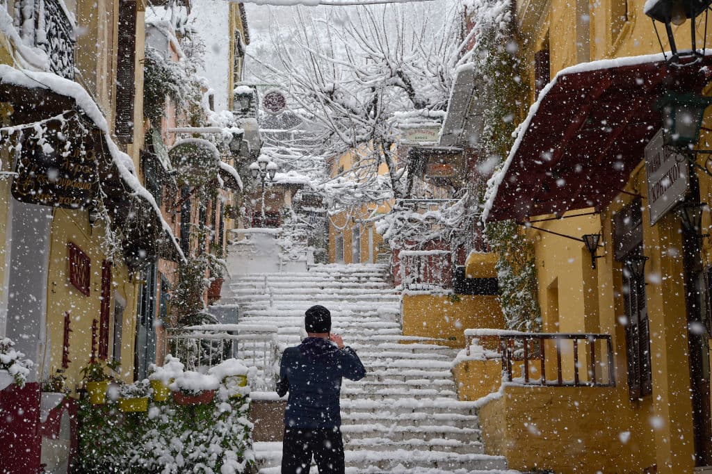 Un hombre en la turística zona de Plaka, en la capital griega, cubierta de nieve. Esta zona está justo debajo de la Acrópolis y es la zona más popular de la ciudad para el turismo.