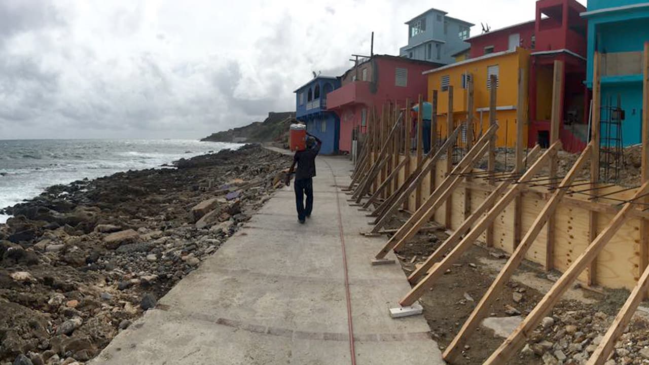 A man walks on the seafront in La Perla, a vulnerable colonial barrio in Old San Juan where hurried fortification were being made on Tuesday after damage from Irma last week.