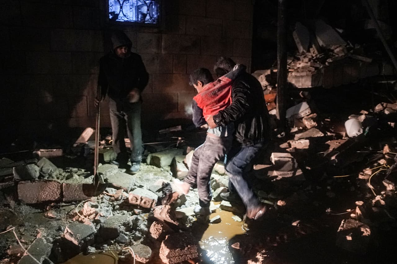 Un hombre carga a un niño herido en el terremoto en el pueblo de Jandaris, en la provincia de Alepo que controlan los rebeldes al régimen de Asad.