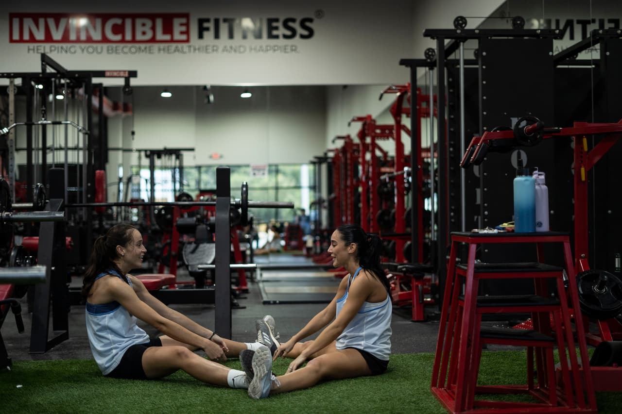 Reina Cruz y Megan Bennett entrenan a diario en el gimnasio más cercano a su vivienda, en una ciudad al norte de Houston. Ambas van a la cancha de fútbol cada tarde después de sus trabajos, donde practican con su entrenador personal.
