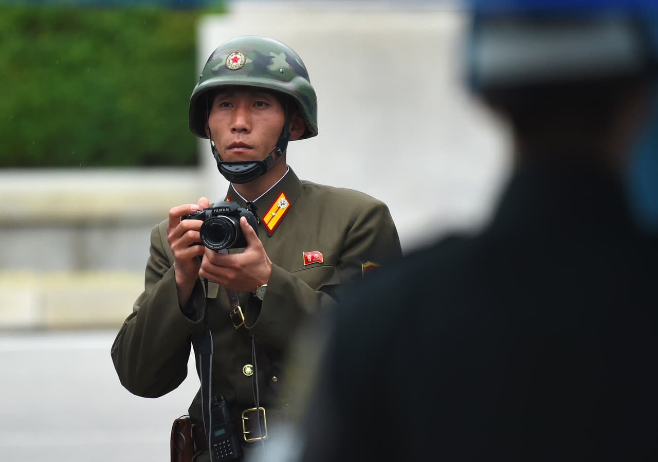 Mientras era informado cerca de la línea de demarcación militar, dos soldados norcoreanos observaban a MIke Pence en la distancia y uno de ellos tomó fotografías.