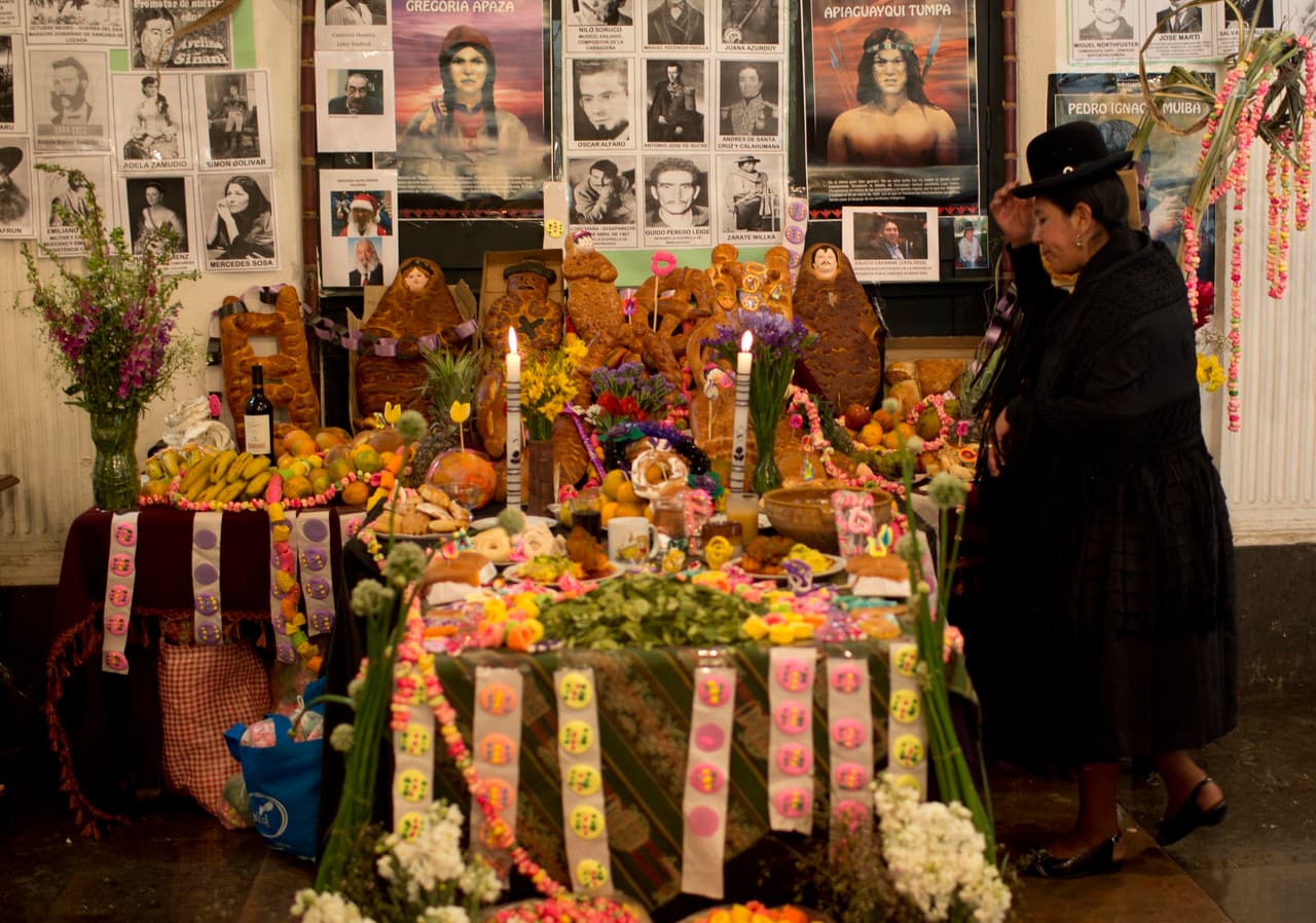 <b>Bolivia.</b> Una mujer se hace la señal de la cruz en un altar que conmemora el Día de Todos los Santos en la sede del congreso nacional, en La Paz.
