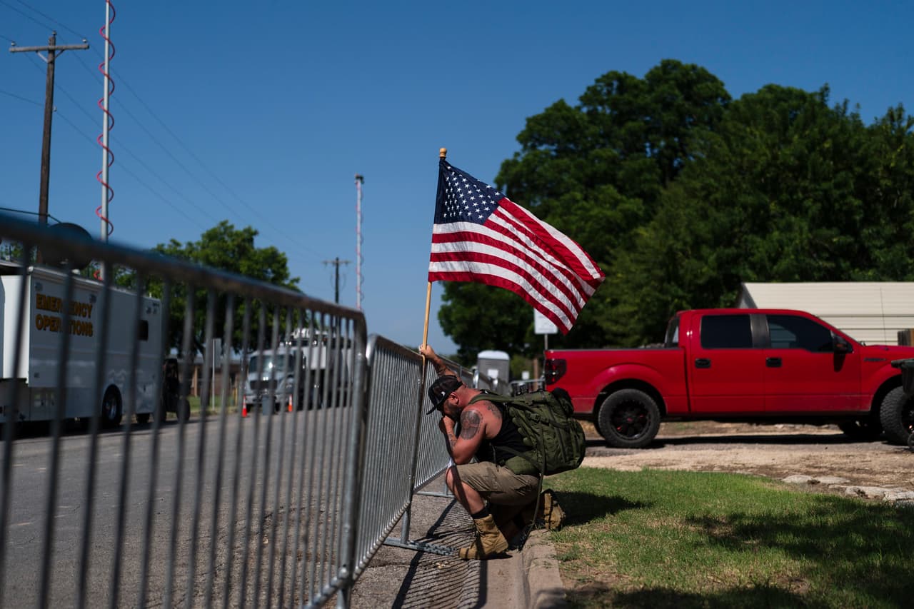 Jarrod Tomassi, de 45 años, sostiene una bandera de Estados Unidos frente a la Escuela Primaria Robb. Las familias de los alumnos recurrieron a las redes sociales en un intento desesperado por encontrar 
<a href="https://www.univision.com/noticias/momentos-de-desesperacion-familiares-cuestionan-a-la-policia-por-no-entrar-inmediatamente-a-la-primaria-de-uvalde-durante-el-tiroteo-video" target="_blank">a sus hijos</a> desaparecidos.