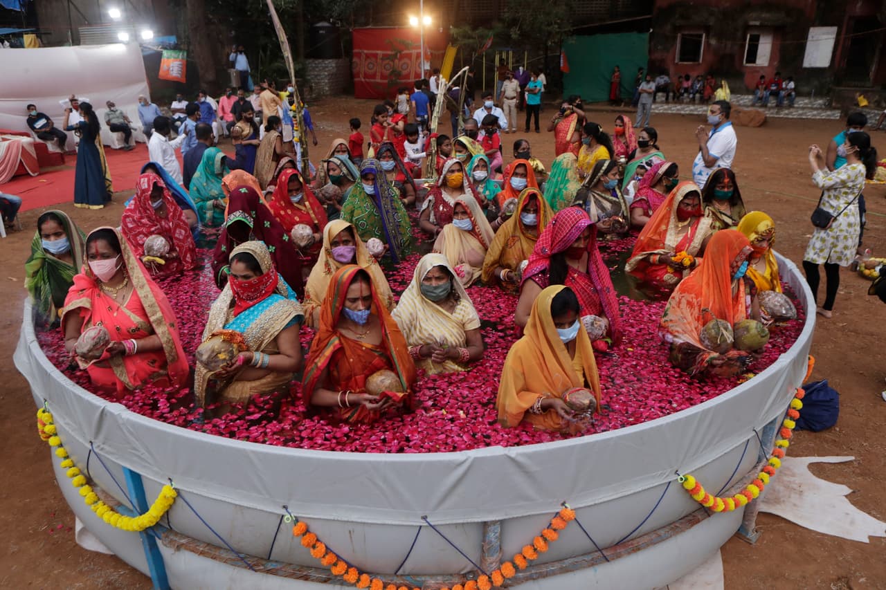 Mujeres hindúes realizan un ritual en un estanque artificial durante el festival Chhat Puja, realizado en noviembre pasado. Expertos apuntan a que la falta de distanciamiento social provocó un aumento exponencial de casos y muertes hasta que la emergencia 
<a href="https://www.univision.com/noticias/mundo/india-pandemia-muertos-contagios-record">rebasó al sistema de salud de India</a> en la primavera de 2021. 
<br>