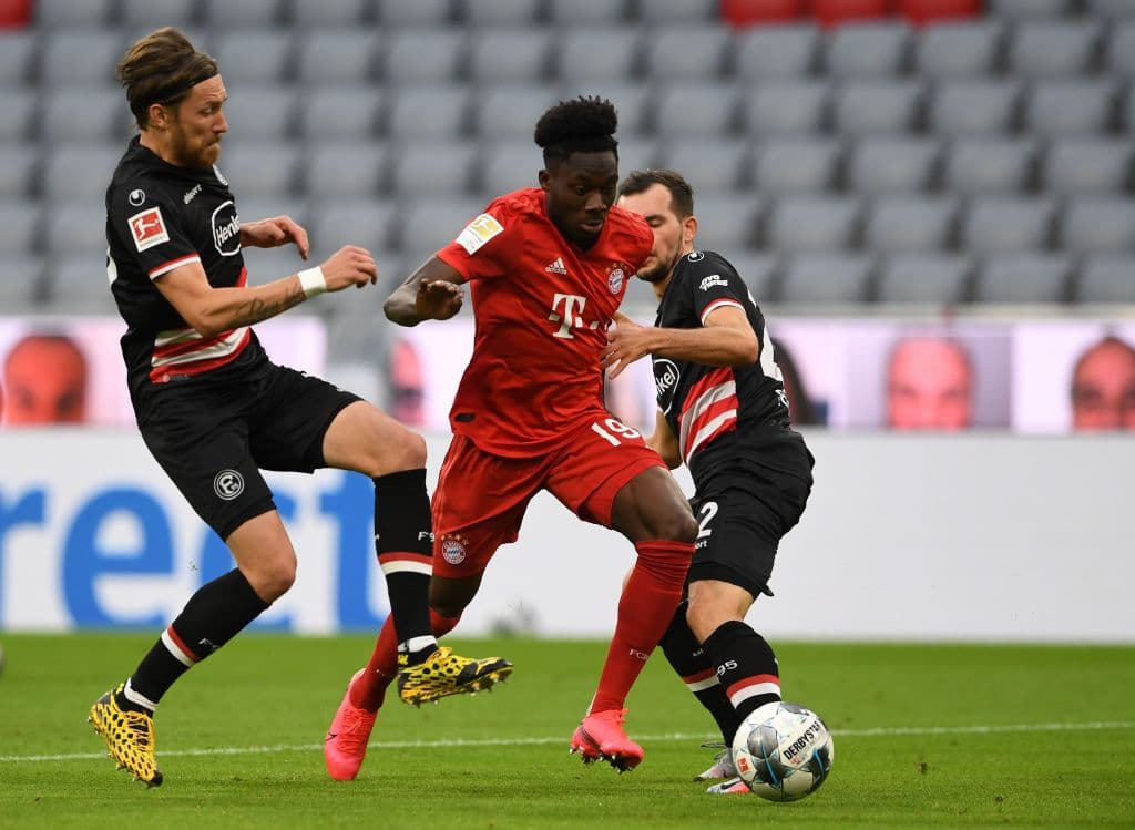 Bayern Munich's Canadian midfielder Alphonso Davies (C) and Fortuna Duesseldorf's Austrian midfielder Kevin Stoeger (R) vie for the ball during the German first division Bundesliga football match FC Bayern Munich v Fortuna Duesseldorf on May 30, 2020 in Munich, southern Germany. (Photo by Christof STACHE / various sources / AFP) / DFL REGULATIONS PROHIBIT ANY USE OF PHOTOGRAPHS AS IMAGE SEQUENCES AND/OR QUASI-VIDEO (Photo by CHRISTOF STACHE/AFP via Getty Images)