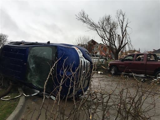 Un vehículo dañado y casas a lo lejos después de que un tornado tocó a Rowlett, Texas.