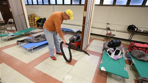 Dave Ames, miembro de Nameoki United Methodist Church, usa una aspiradora para succionar el agua que se filtró en el sótano de la iglesia.