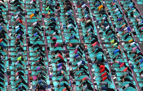 Una multitud de personas participa en una sesión masiva de yoga en Times Square (Nueva York) durante un evento que celebra el solsticio de verano, que este año coincide con el Día Internacional del Yoga.