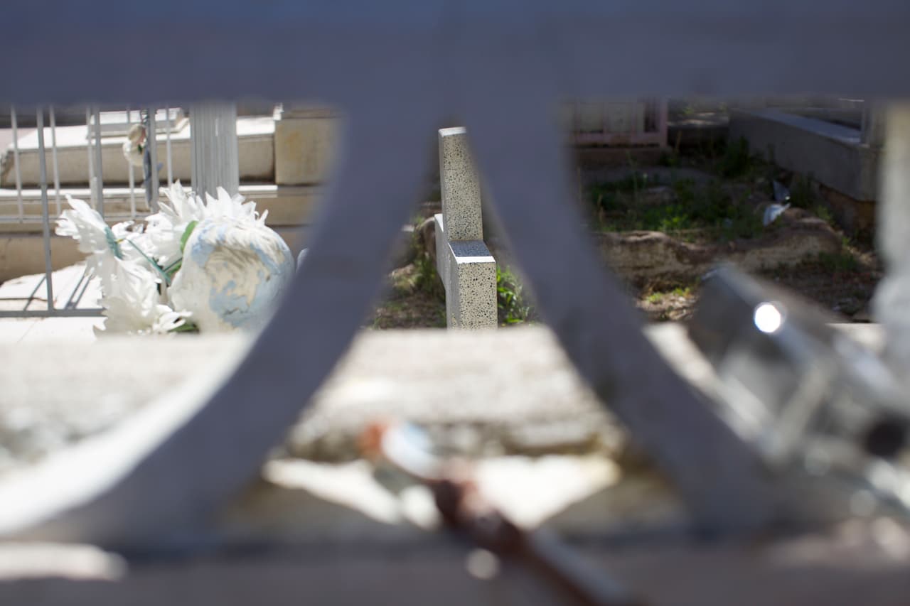 El muro del cementerio se ha convertido en una repisa para colocar un cepillo de dientes y un frasco de loción vacío. La mayoría de las familias centroamericanas llevan más de dos meses viviendo en el campamento.