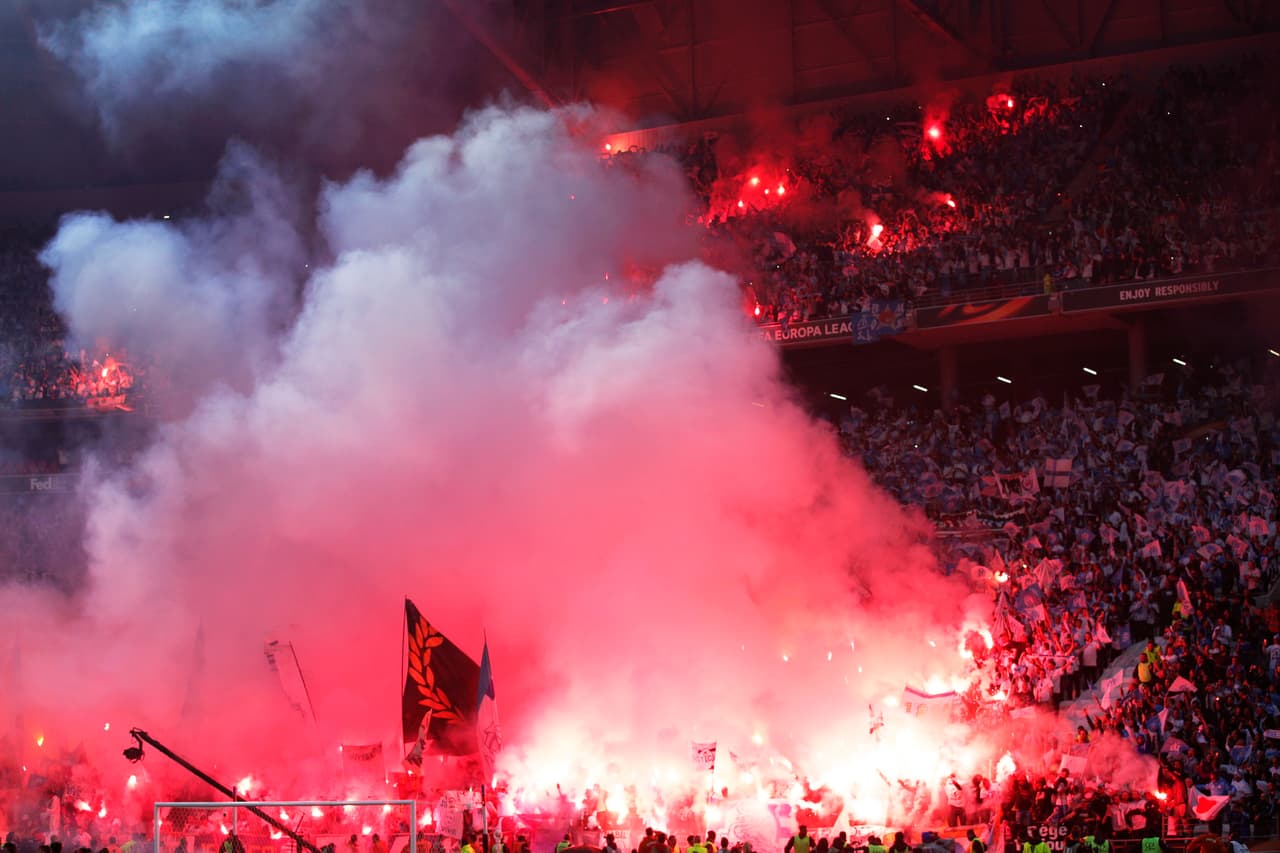 Mientras se desarrollaban los actos protocolarios antes del inicio de las acciones entre el Atlético de Madrid y el Marsella, los aficionados ques estaban ubicados en la zona sur del estadio montaron un infierno a base de bengalas. Seguramente, la UEFA sancionará al equipo por el comportamiento de sus ultras, los cuales tienen muy mala fama en Europa.