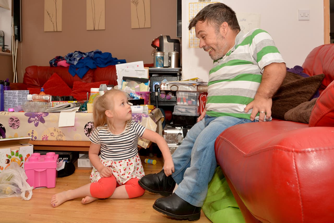 La tierna pequeña ata los cordones de su papá cuando estos se deshacen.