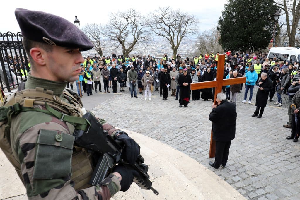 Guardias armados cuidan a Michel Aupetit, Arzobispo de París, durante la ceremonia de Viernes Santo en la Basílica del Sagrado Corazón en la capital francesa.