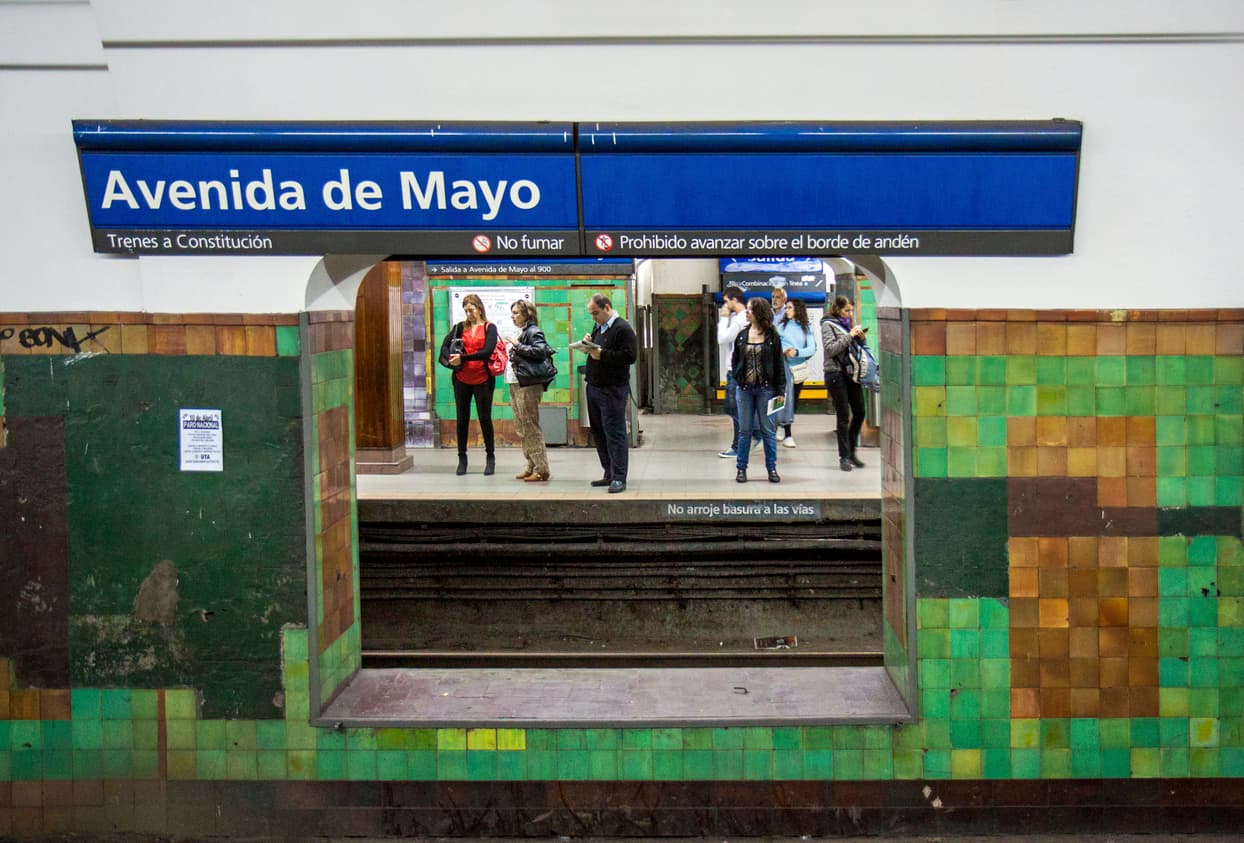 Buenos Aires, Argentina - April 11, 2014: Subway station Avendia de mayo. looking from one platform through a wall to the other where people are waiting.