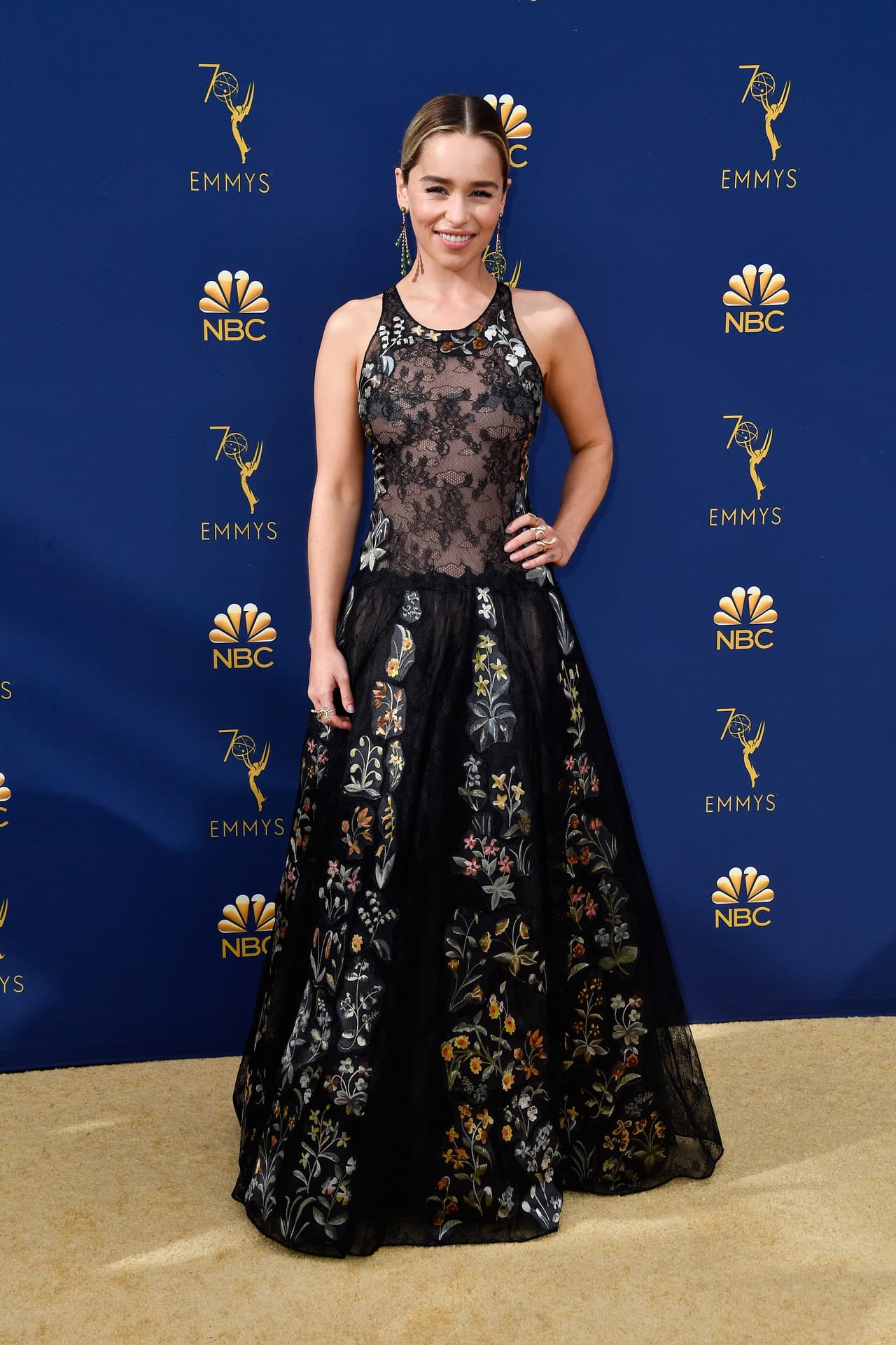Emilia Clarke, una de las protagonistas de 'Game Of Thrones' desfiló por la alfombra dorada con este vestido negro con encaje y detalles de flores en la falda. La actriz no compitió en ninguna categoría.